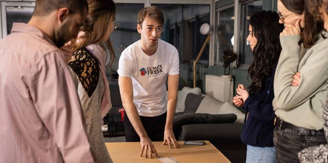 Group of people standing around a table and talking to each other
